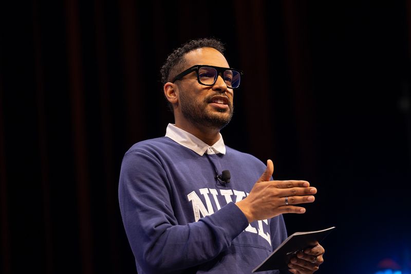 Nick Boyd on stage in a Nike crewneck, mid-talk.